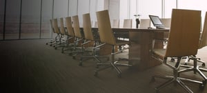Executive board room with long table and rolling chairs