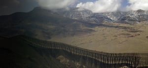 Large mountain range with clouds above it