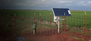 Nanometrics branded array station in open natural area surrounded by a metal fence