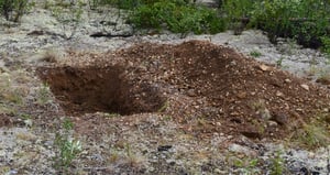 Large hole dug in the earth for burial of a seismometer