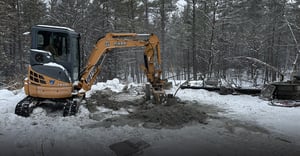 Bobcat filling in dirt around boreholes