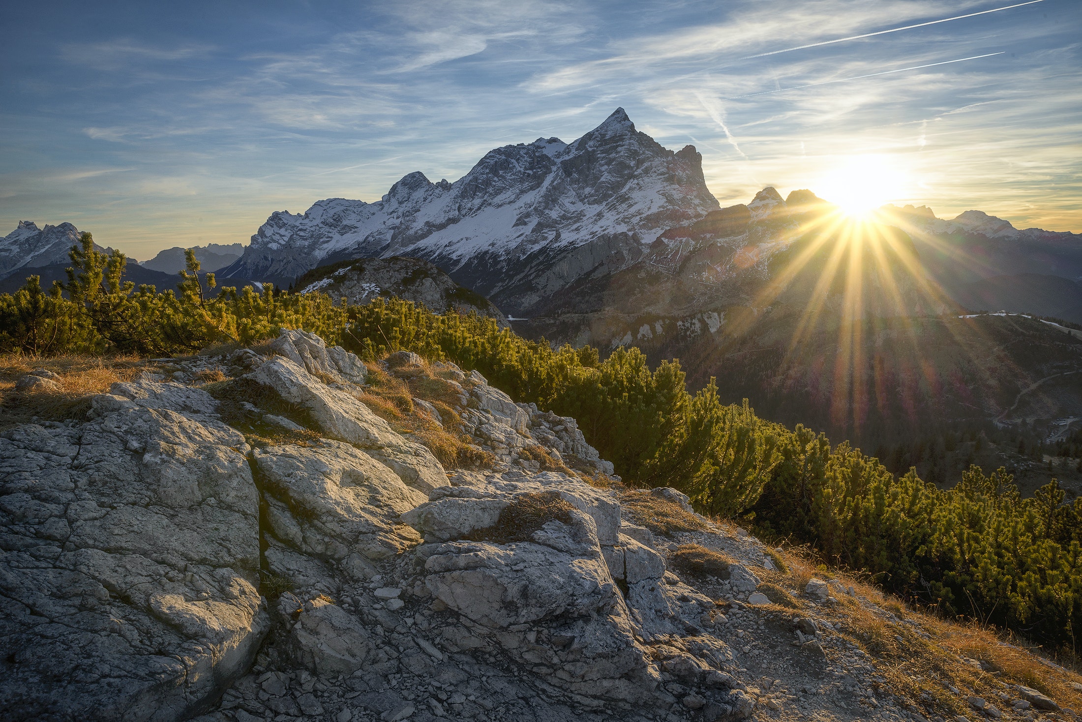 Sunset over rocky terrain with mountain in the background