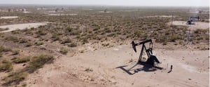 Large oil field with several oil derricks dispersed across it