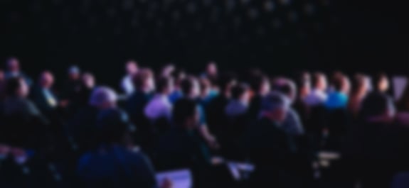 Large audience sitting in theatre chairs