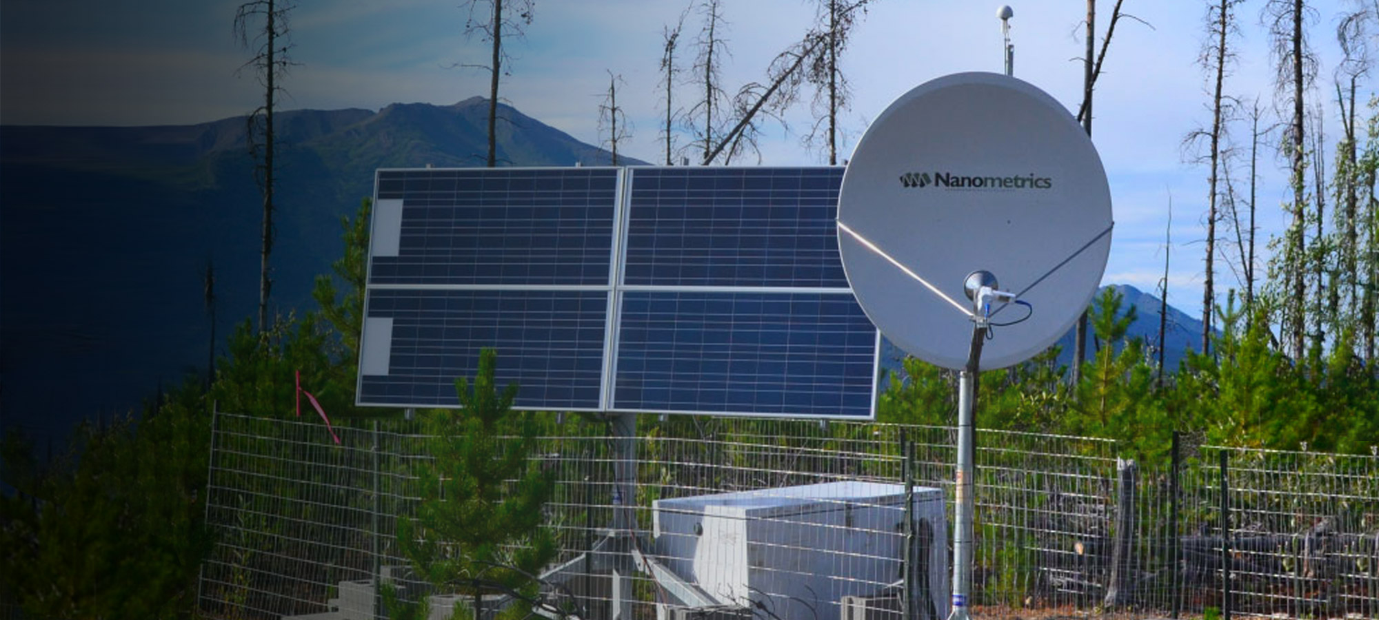 Seismic station with solar panel and communications dish in a wooded area